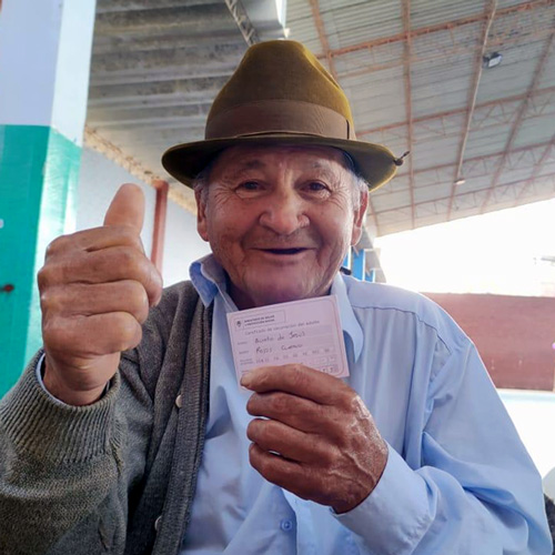 Hombre colombiano de la tercera edad mostrando un carnet de vacunación